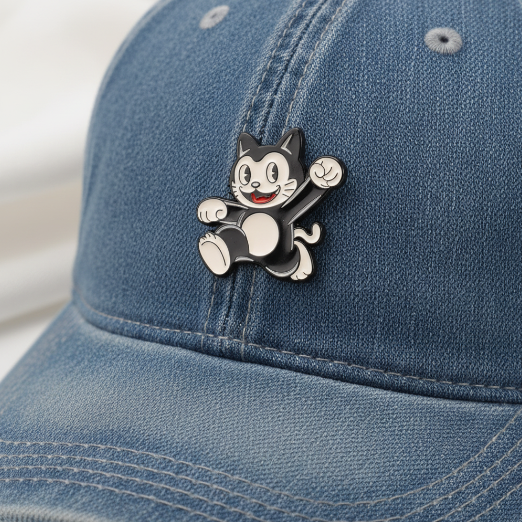 Black and white cat-shaped lapel pin on a denim surface