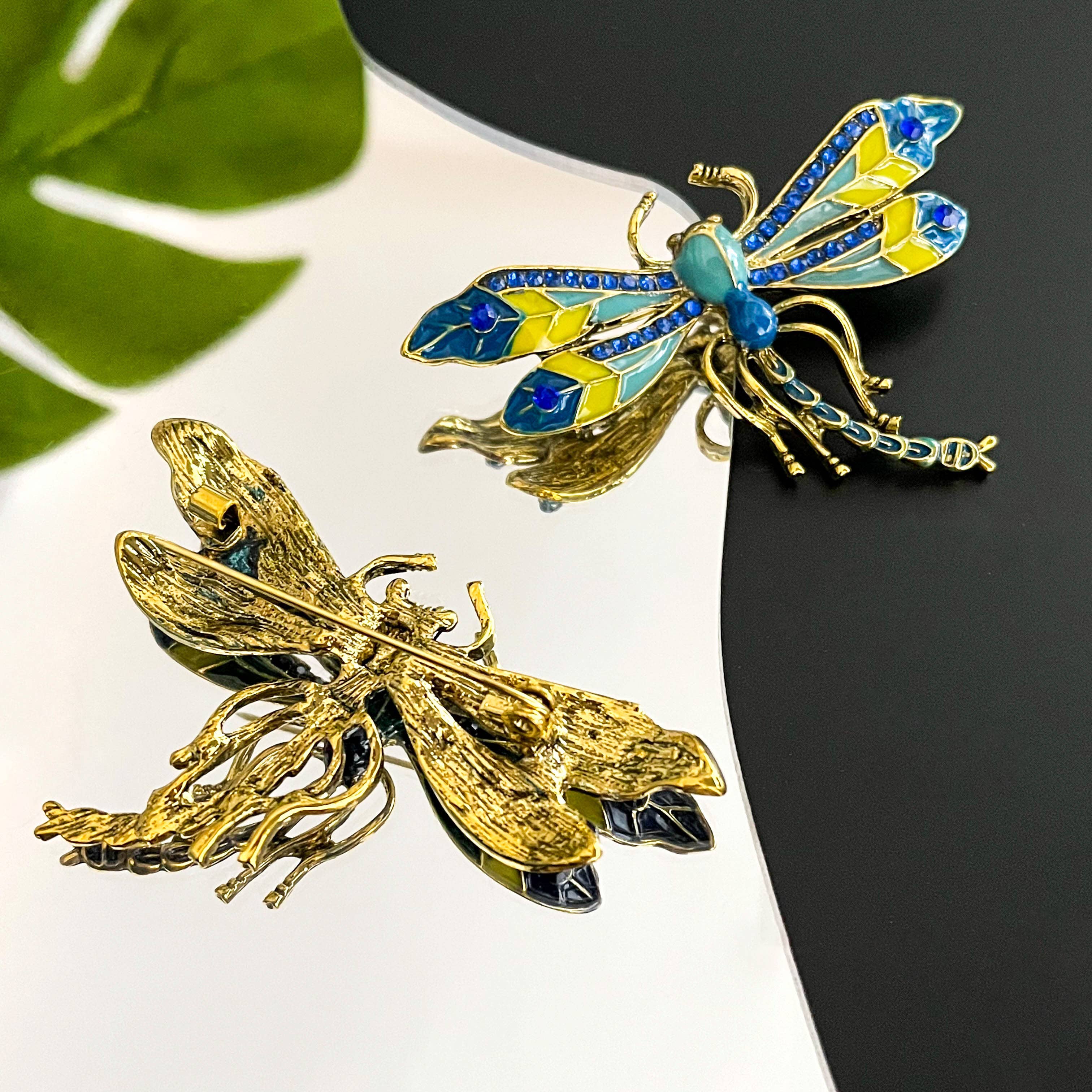 Front view and back view of colorful dragonfly brooches with golden accents, showing the clasp mechanism