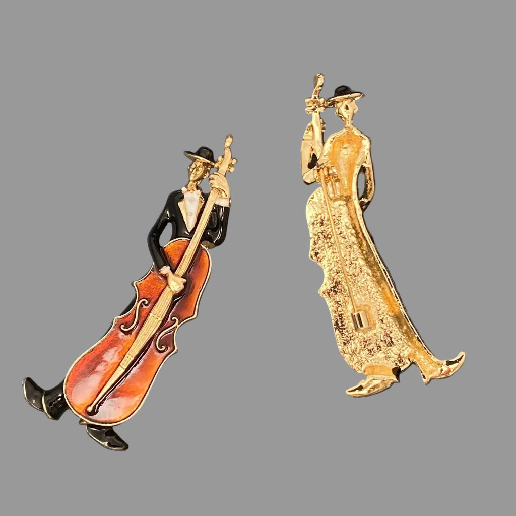 Front and back view of a decorative pin of a musician playing a cello on a gray background