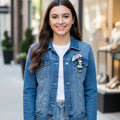 Colorful brooch of a girl with an umbrella, pinned on a denim jacket