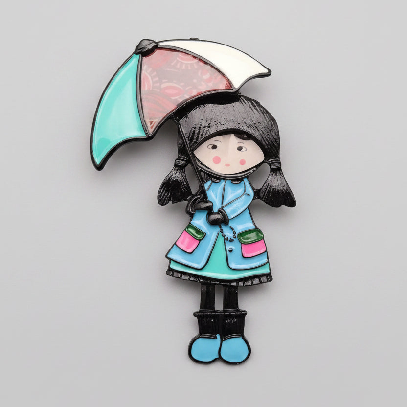Colorful brooch of a girl with an umbrella on a textured surface