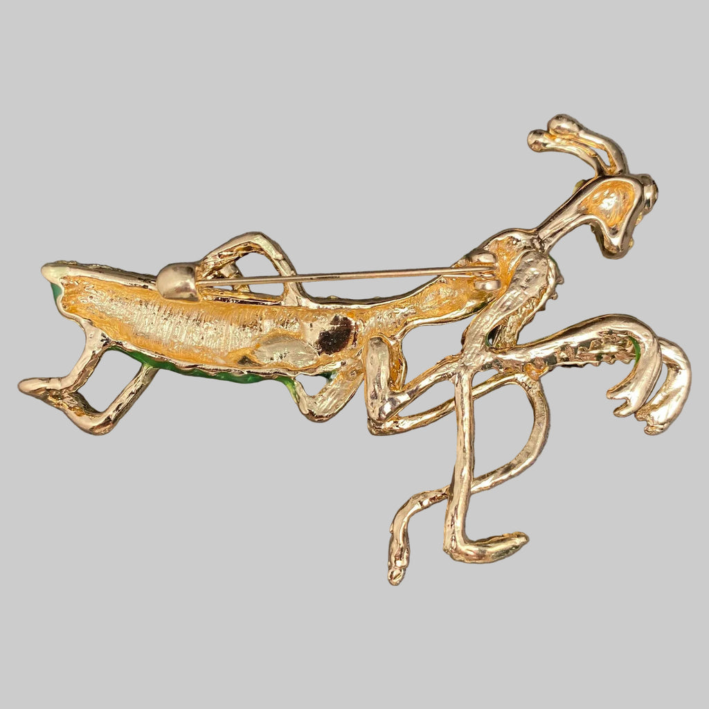Back view of decorative mantis brooch with green and gold details, showing the clasp mechanism