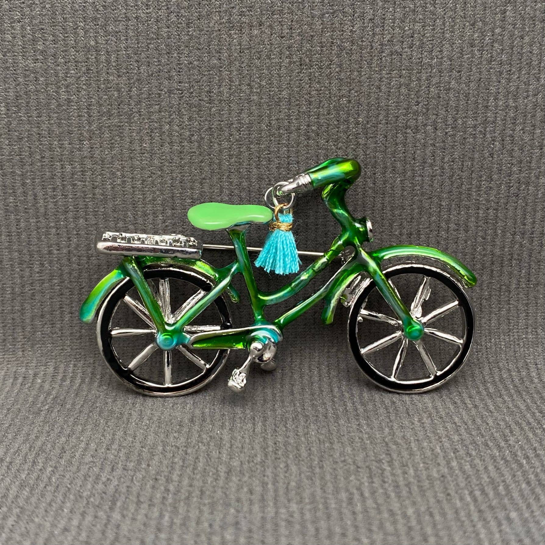 Green enamel bicycle-shaped brooch with blue tassel handle bars