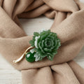 Green jade flower brooch pinned on a linen scarf