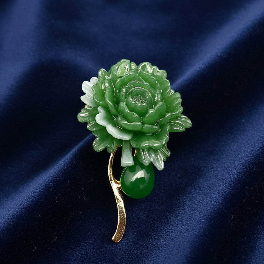 Green jade flower brooch on a blue background