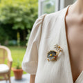 Hedgehog brooch holding a flower pinned on a beige dress