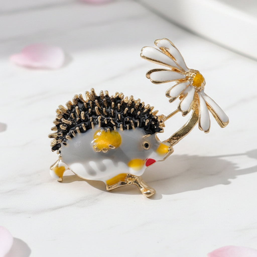 Hedgehog brooch holding a flower on a soft white background