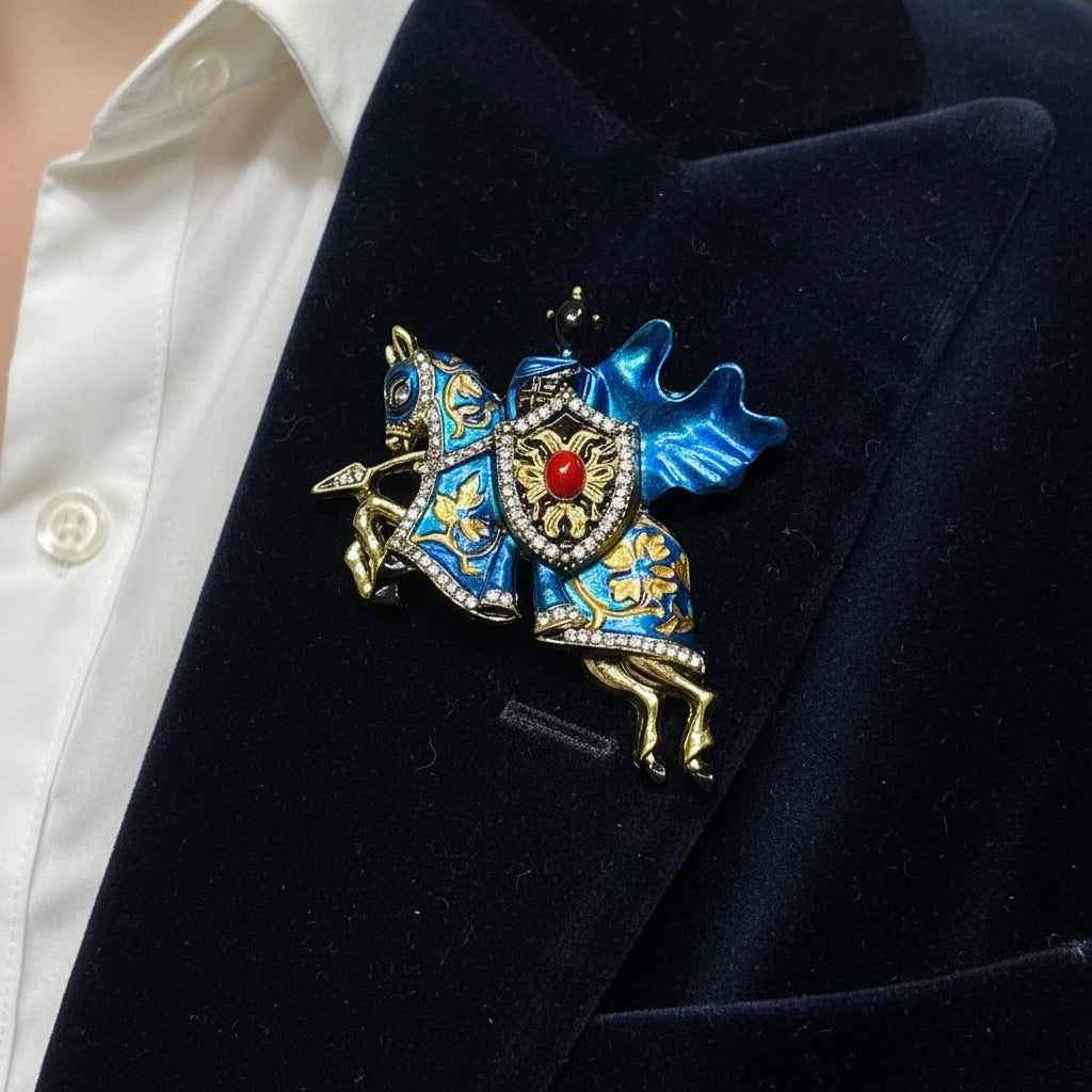 Jousting knight on horse brooch with carved gold and blue metal accents and rhinestone detailing
