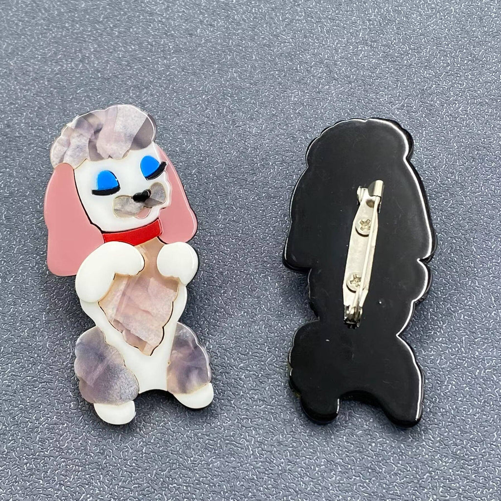 Dog-shaped brooch with pink, white, and red colors on a gray background