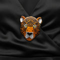 Leopard head design brooch on a black background