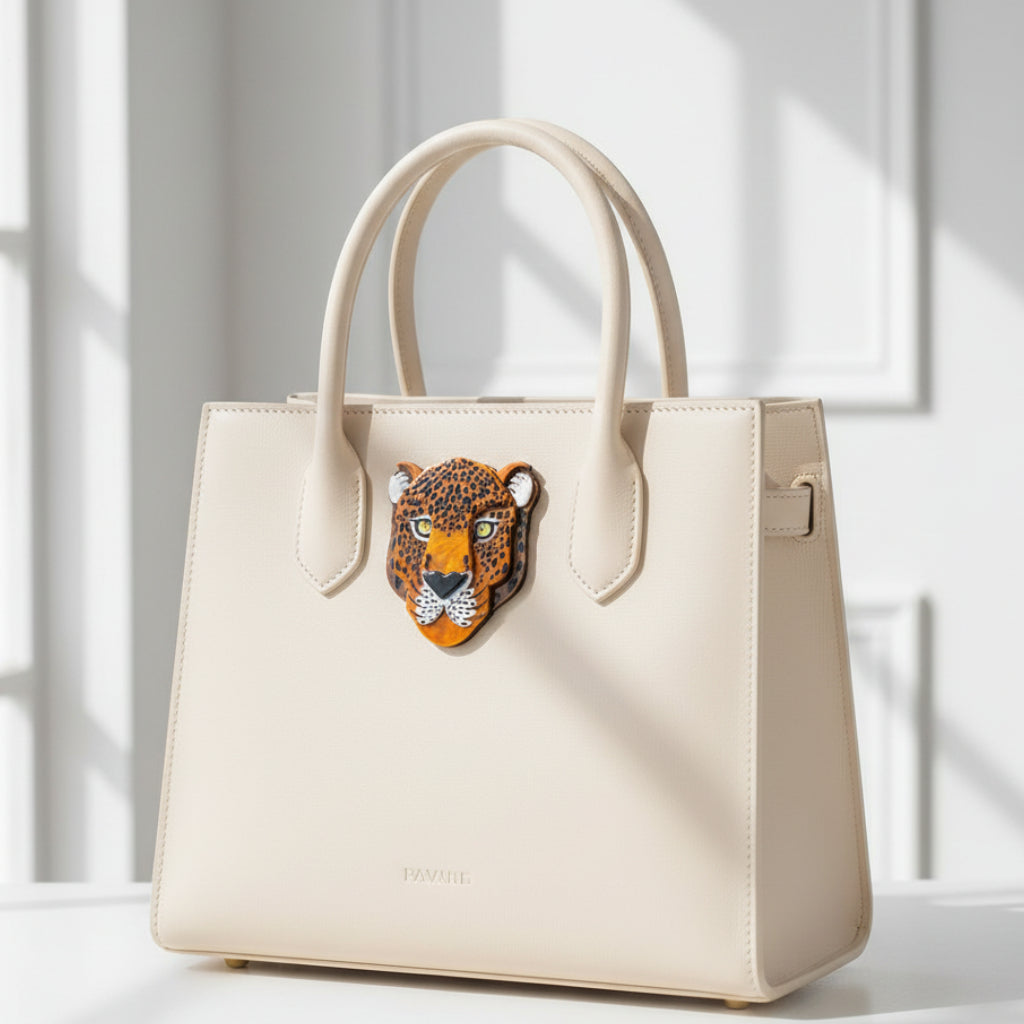 Leopard head design brooch pinned on a white handbag with a light background