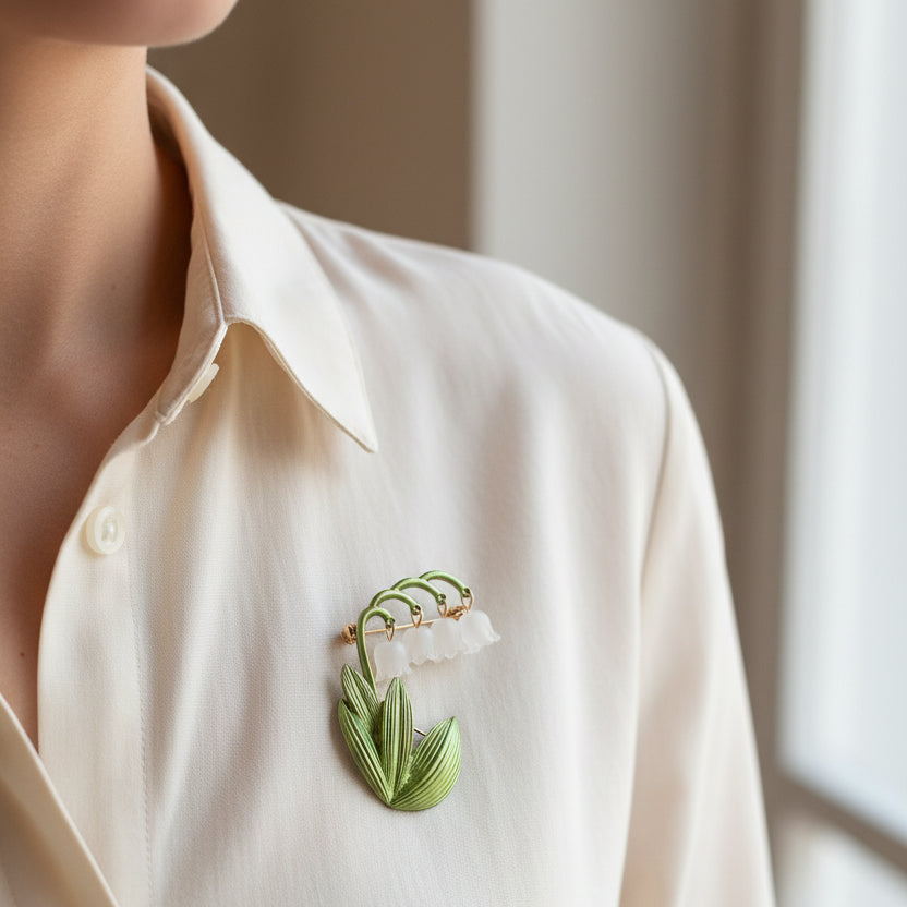 Lily of the valley brooch pinned on a woman's ivory blouse