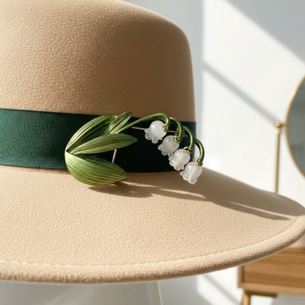 Lily of the valley brooch pinned on a beige hat with green trim
