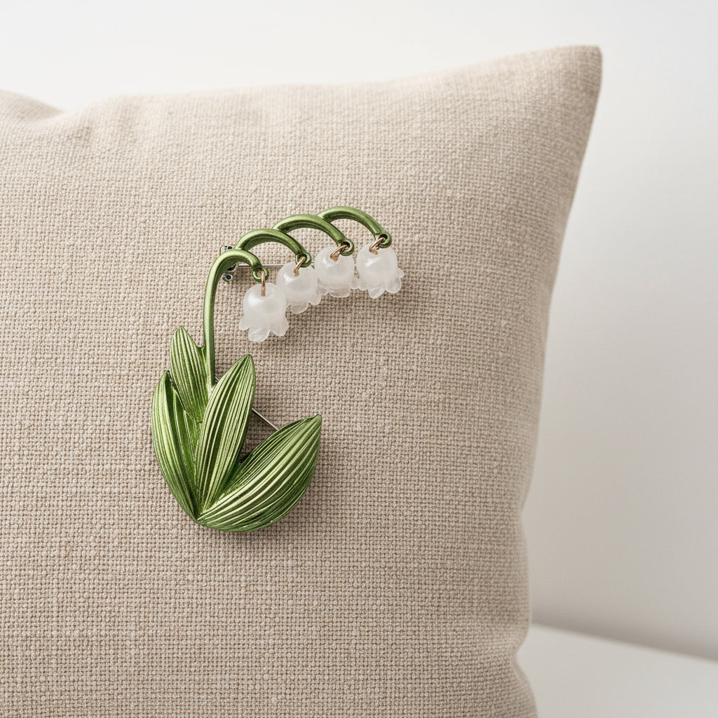 Lily of the valley brooch pinned on a linen pillow