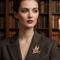 Gold pegasus brooch with purple and violet gemstones against a dark background