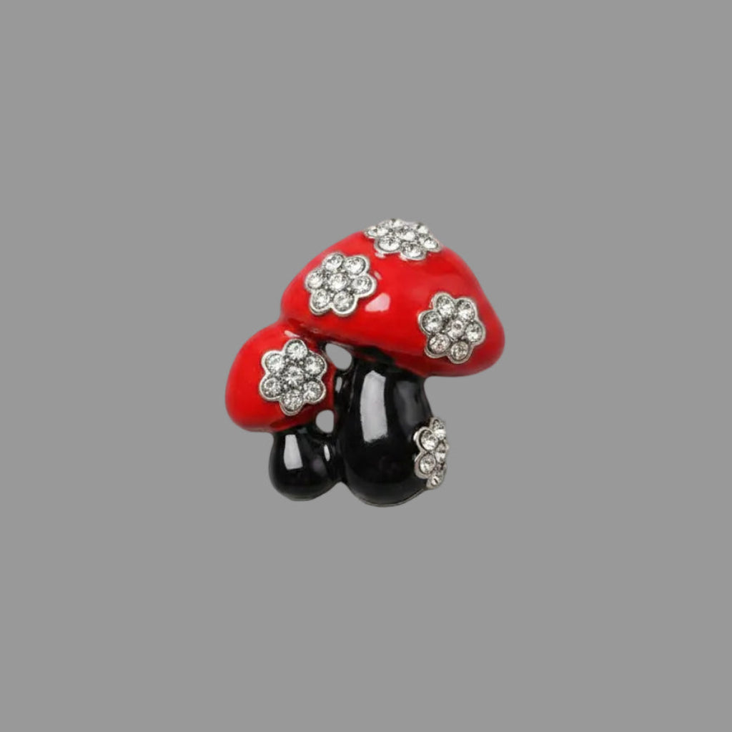 Red mushroom-shaped brooch with crystal accents on a black enamel stems