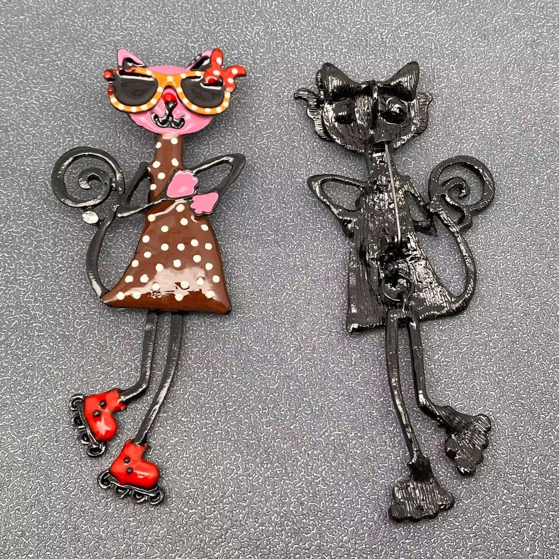 Decorative brooch of a polka dot cat with sunglasses and roller skates on a gray background