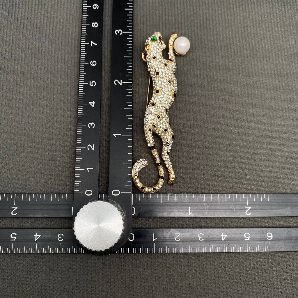 Rhinestone cheetah brooch with green crystal eyes and faux pearl accent in gold-tone finish

