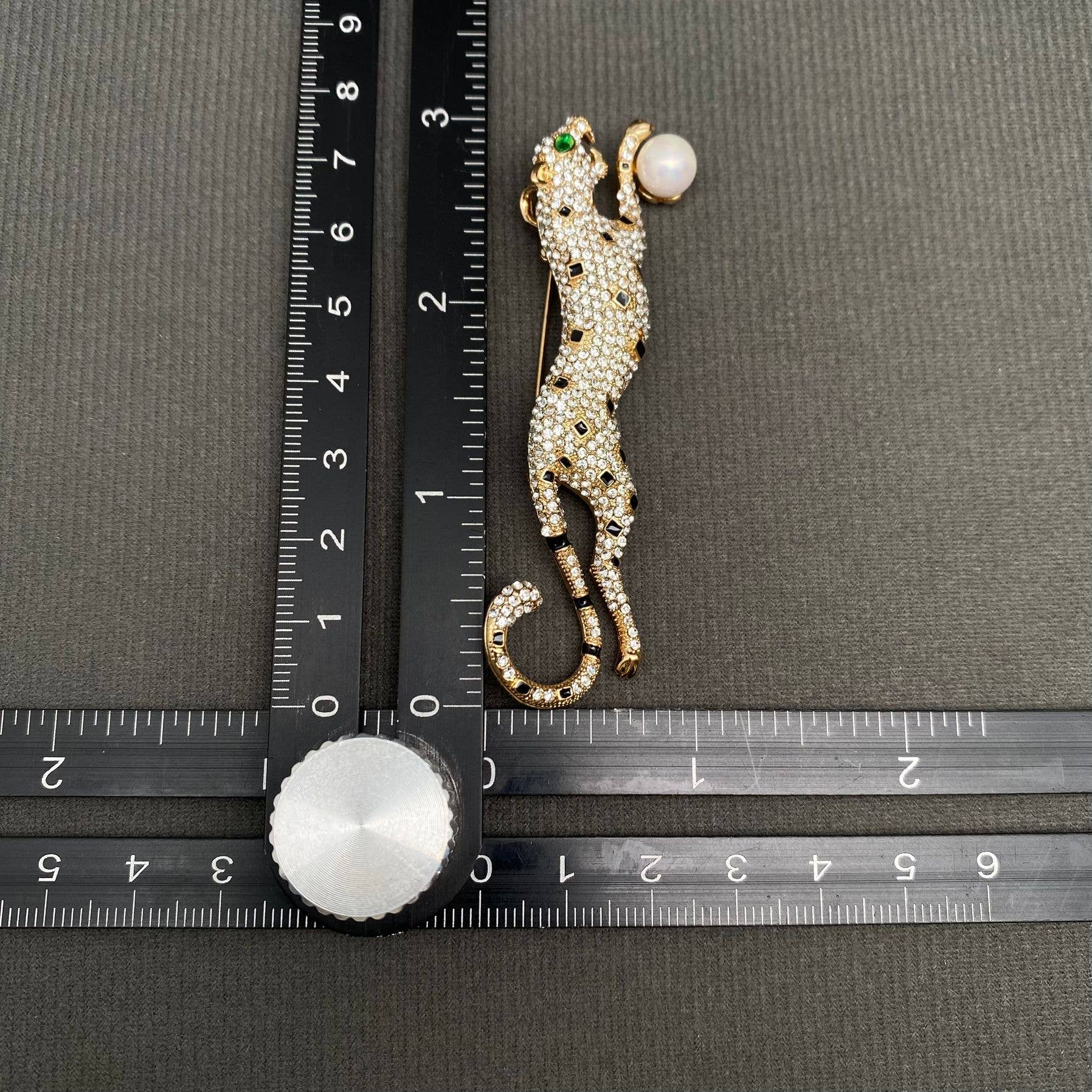 Rhinestone cheetah brooch with green crystal eyes and faux pearl accent in gold-tone finish
