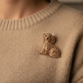 Gold dog-shaped brooch with gemstones pinned on a sweater