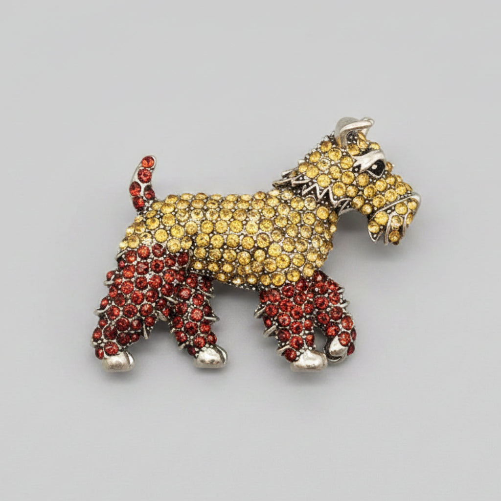 Dog-shaped brooch with yellow and red stones on a white background