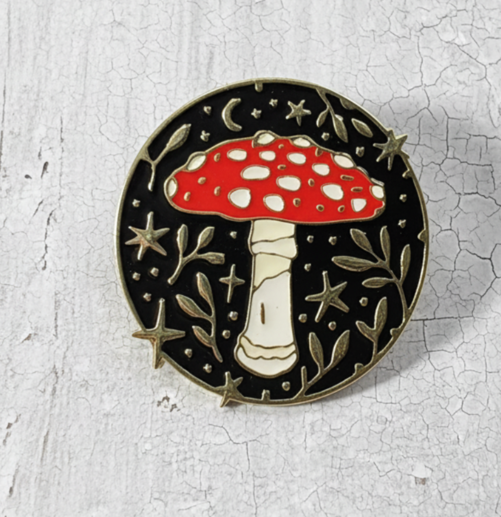 Round mushroom enamel pin with red cap and silver woodland design