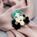 Gypsy girl acrylic brooch pinned on a pink scarf