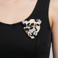Textured acrylic leopard shaped brooch on a black background
