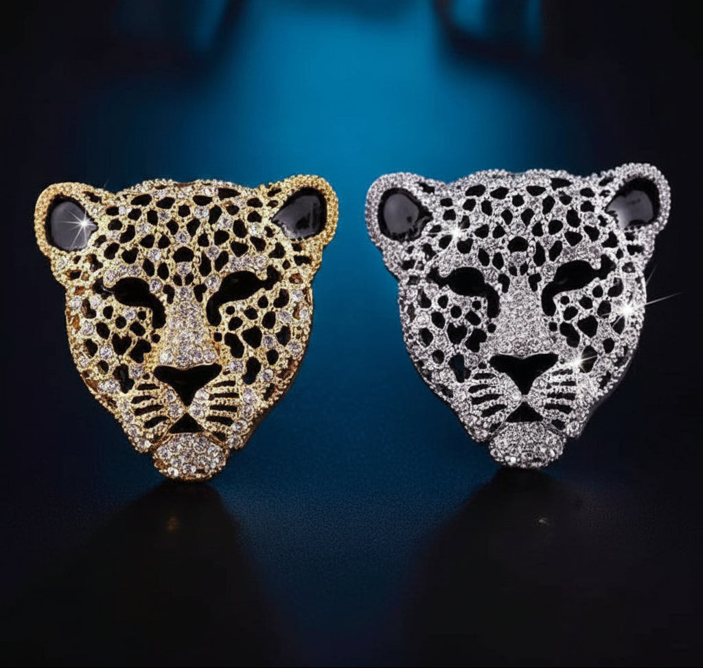 Gold and silver leopard head rhinestone brooches on a blue background