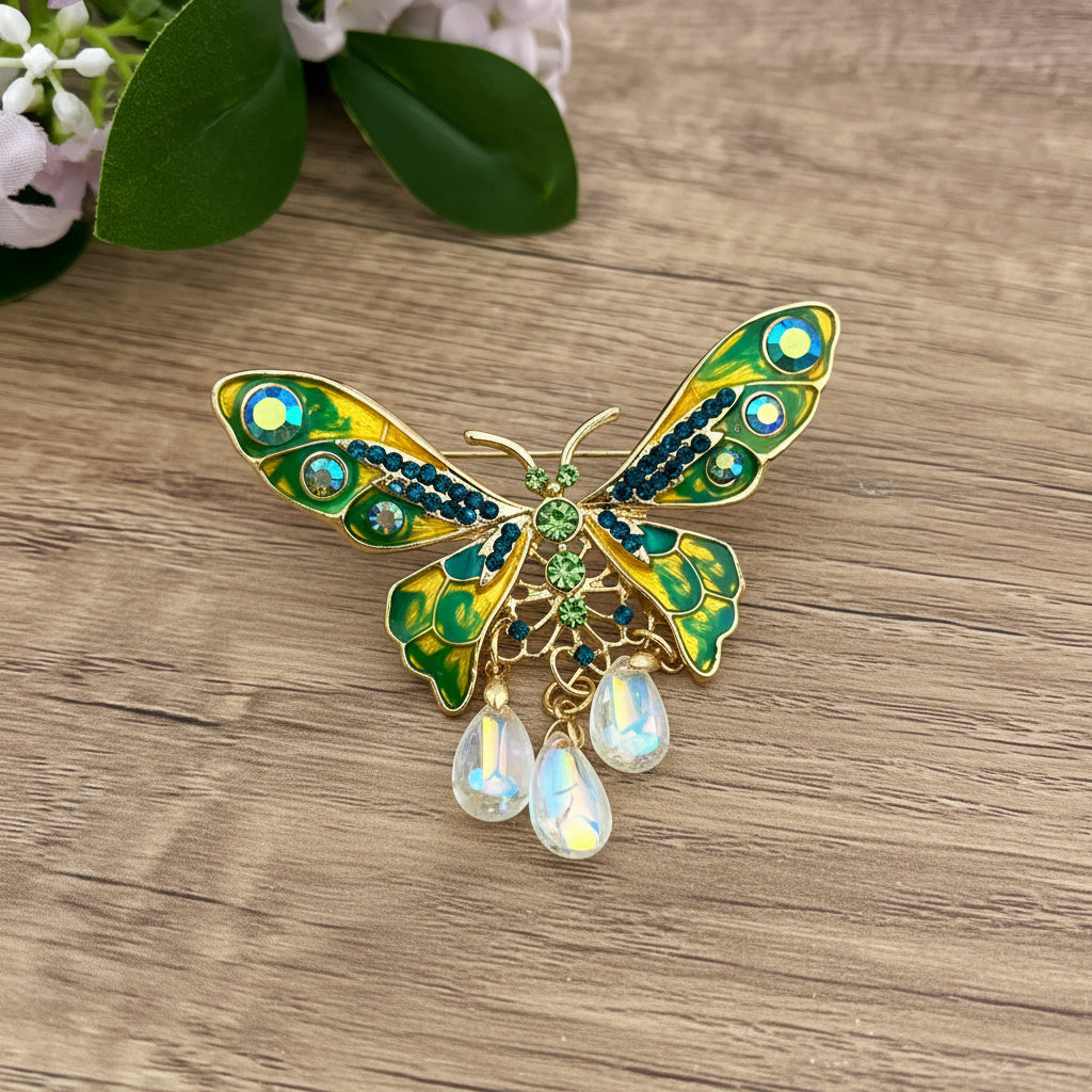 Colorful butterfly-shaped brooch with gemstones, on a wooden surface with flowers in the background