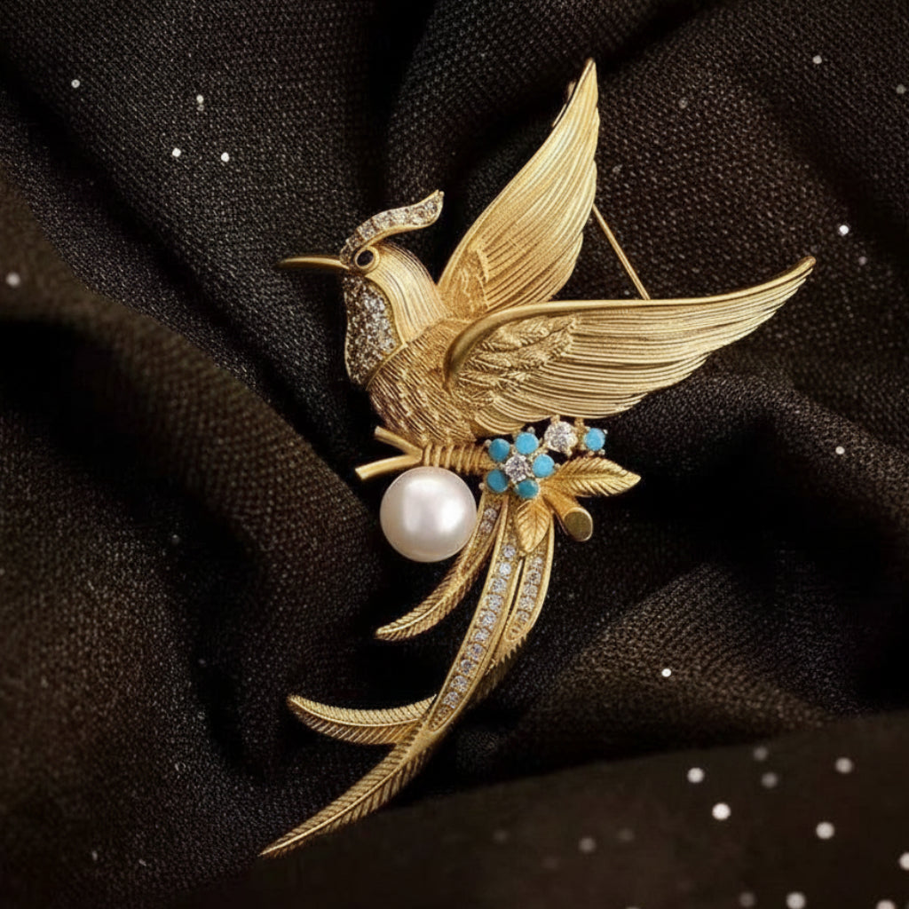 Gold phoenix brooch with pearls and gemstones on a dark fabric background
