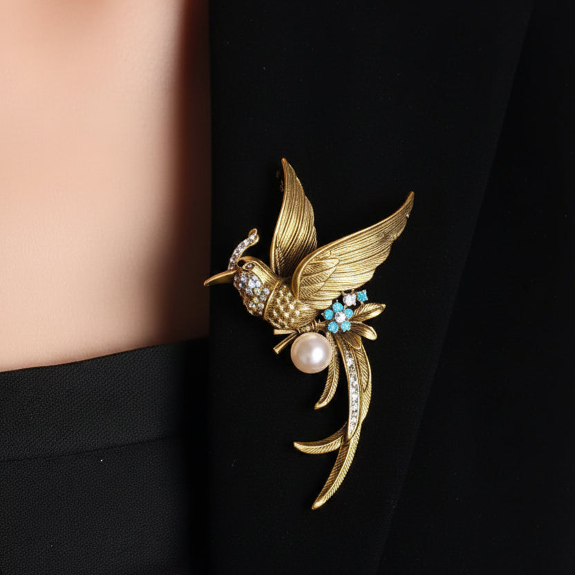 Gold phoenix brooch with pearls and gemstones pinned on a black suite