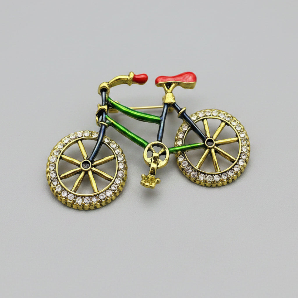 Bicycle-shaped brooch with rhinestone details on a gray background