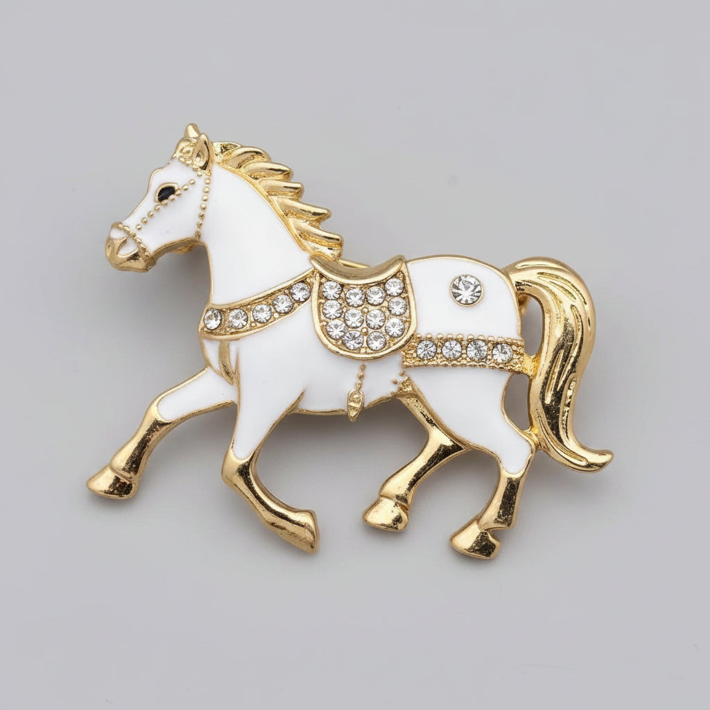 White horse brooch with gold accents and rhinestones on a gray background